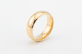 Classic 18K gold stainless steel band ring on white surface, clean professional product photography